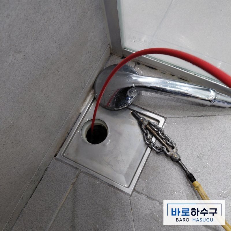 안산 욕실 하수구에서 배관 세척 작업을 하는 모습