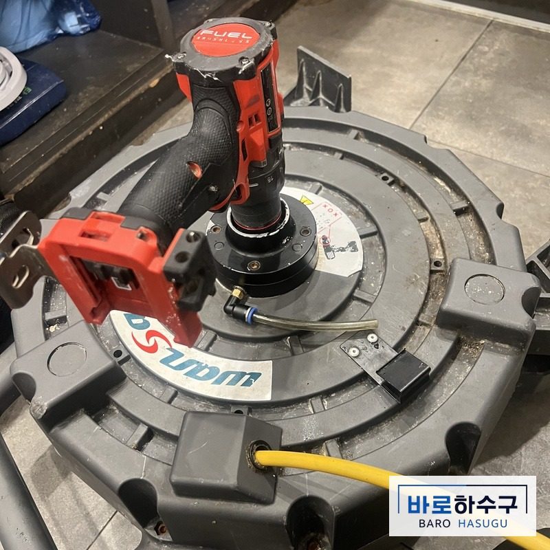카페 바닥에 놓고 쓰는 배관 세척 장비와 케이블 릴