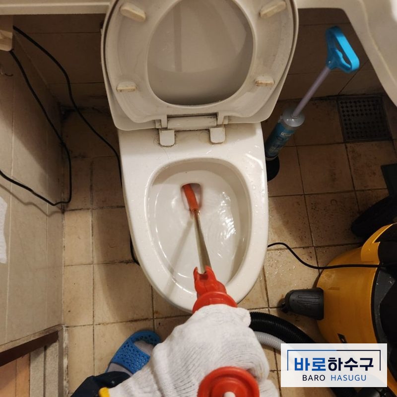 관통기를 변기에 넣어 걸린 물티슈를 풀어내는 작업 모습