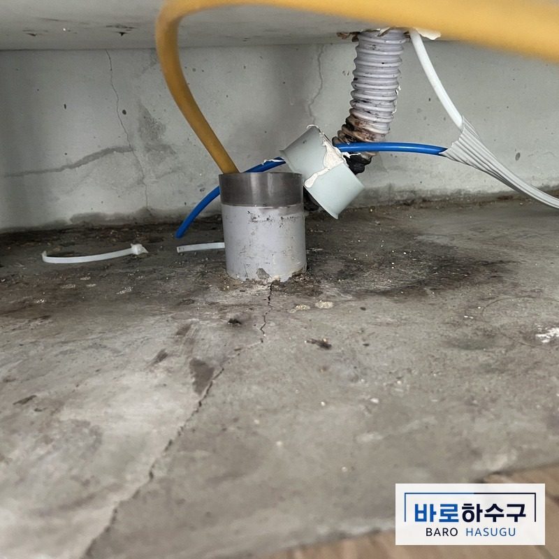 화성 동탄 현장 싱크대 하부장, 역류한 물로 배관 둘레 바닥이 젖은 모습