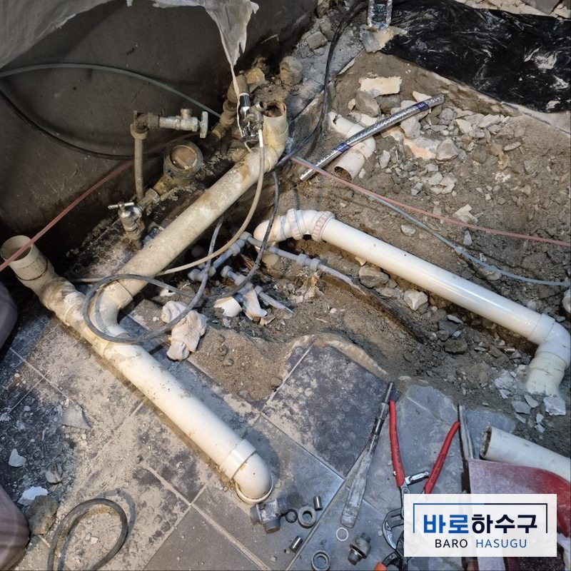 군포 현장 바닥을 열고 주철관 대신 새로 설치한 흰색 PVC 가지 배관