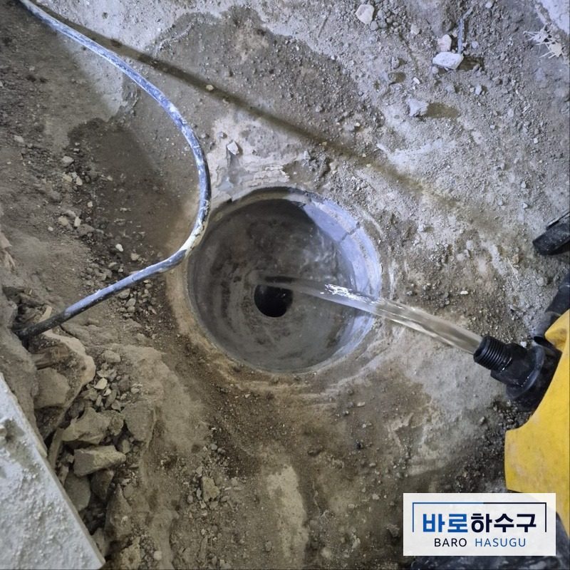 굳은 시멘트를 제거한 뒤 물을 부어 배수를 확인하는 남양주 현장 변기 배관